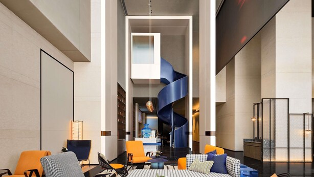 Un intérieur moderne avec un escalier en colimaçon central, des espaces de détente et un bar.
