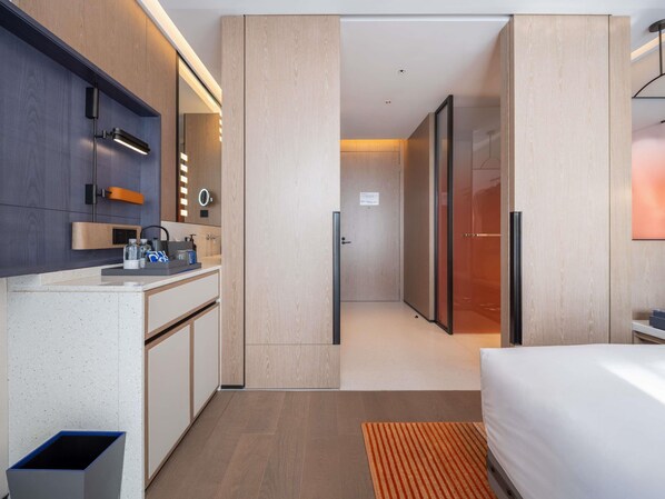 Une chambre d’hôtel moderne équipée d’une kitchenette, d’un lit et d’une salle de bain.