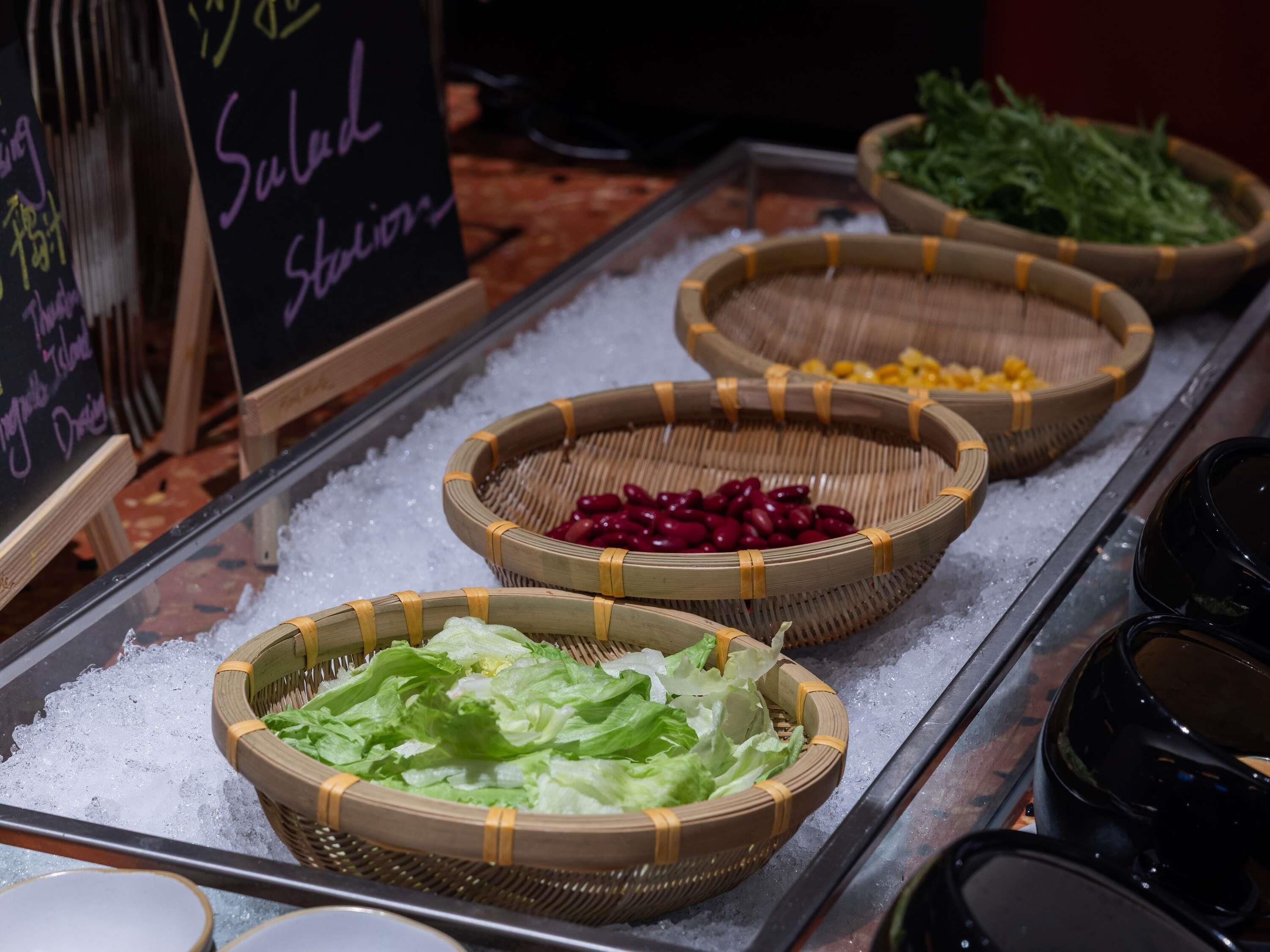 A buffet with various food items displayed in baskets on a tray.