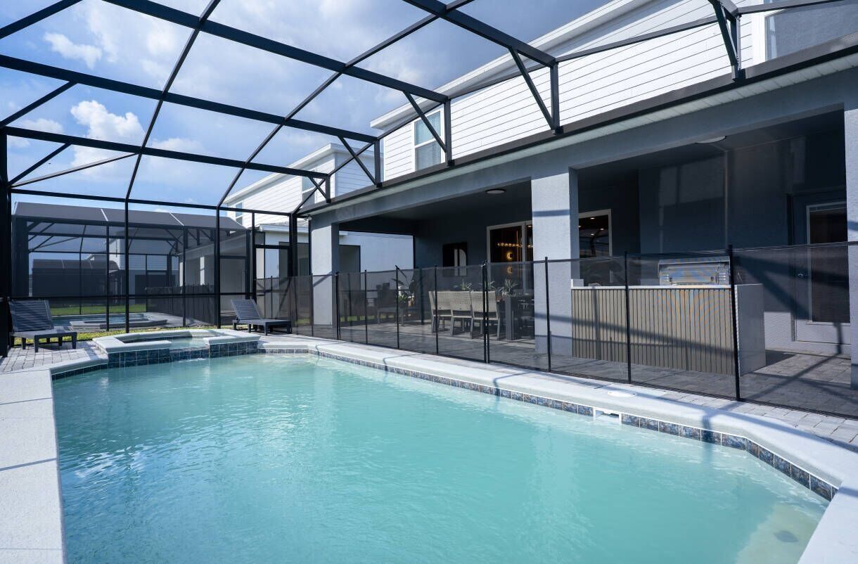Piscina com cobertura de vidro, cadeiras de descanso e área de terraço.