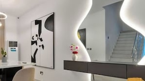 En modern inredning med en böjd väggdesign, en trappa och en minimalistisk stil.