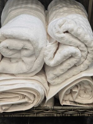 A stack of white towels in a basket.