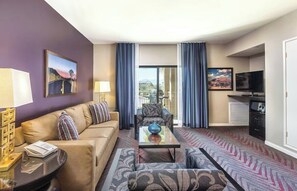 A hotel room with a sofa, armchair, coffee table, TV, and a view of the outdoors. - Charming Wyndham 1-Bedroom Indio Condo with Loads of Resort Amenities (Indio)