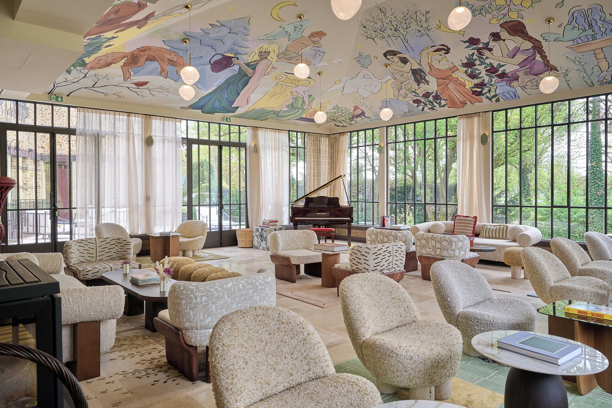 Une pièce spacieuse avec un grand piano, des sièges confortables et de grandes fenêtres donnant sur l’extérieur.