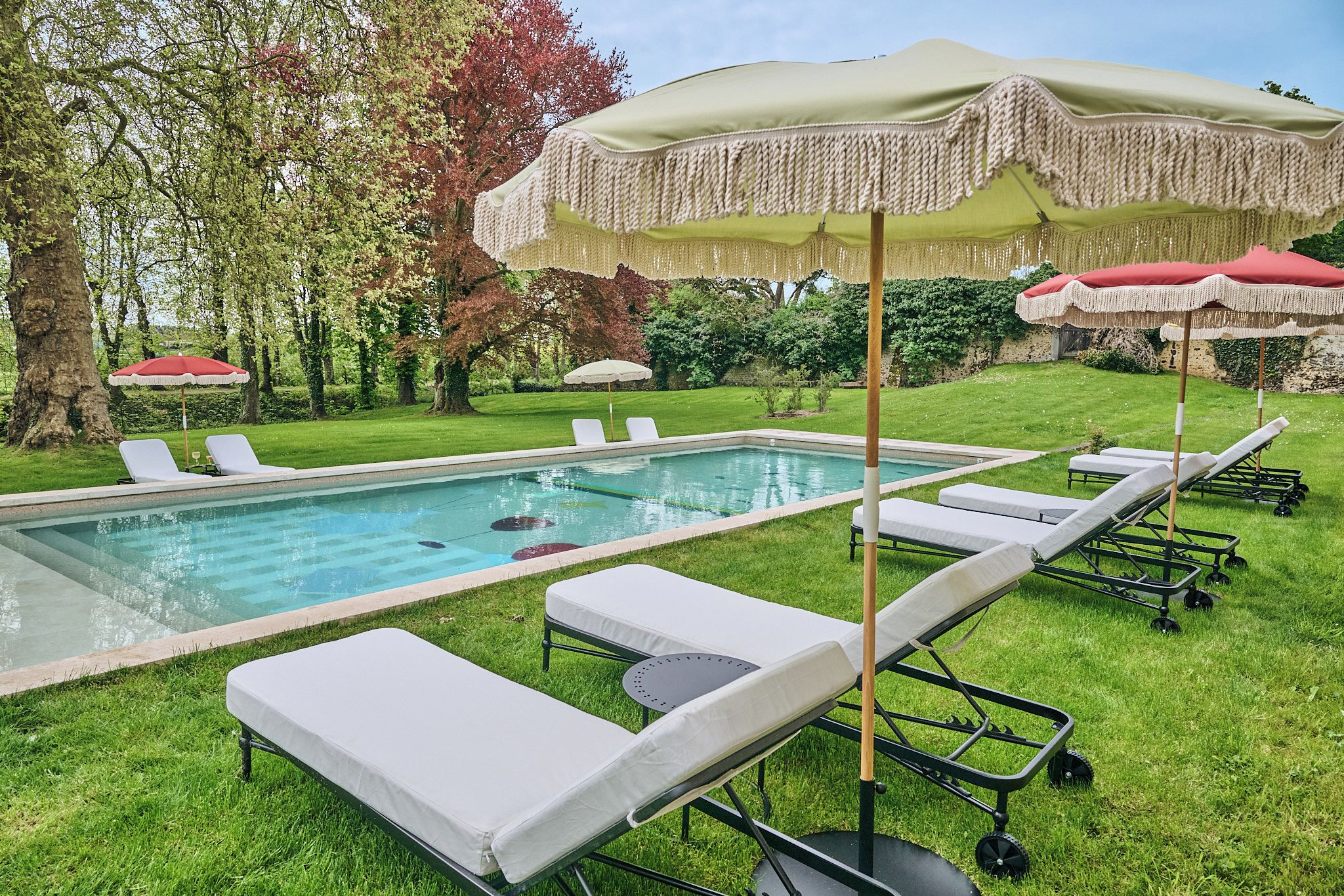 Ein Schwimmbad mit Liegestühlen und Sonnenschirmen.