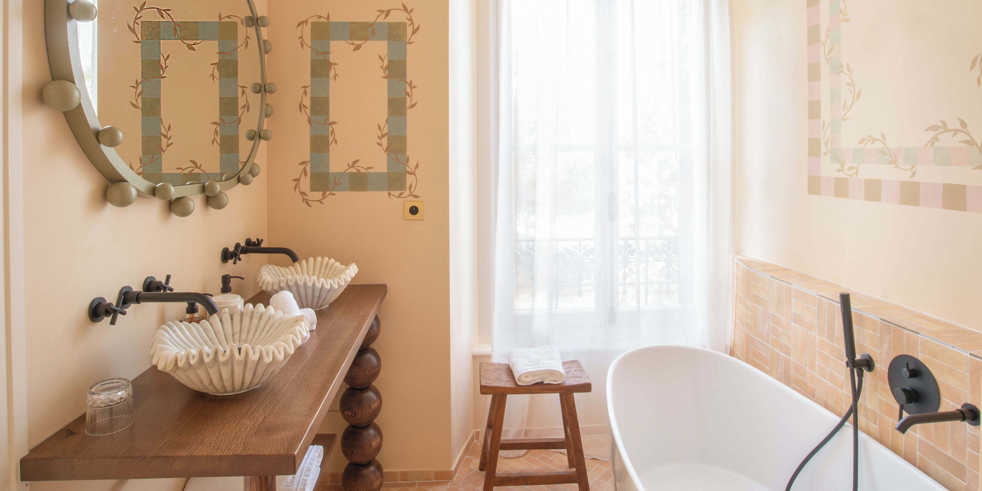 A bathroom with a wooden vanity, two sinks, a mirror, and a bathtub.