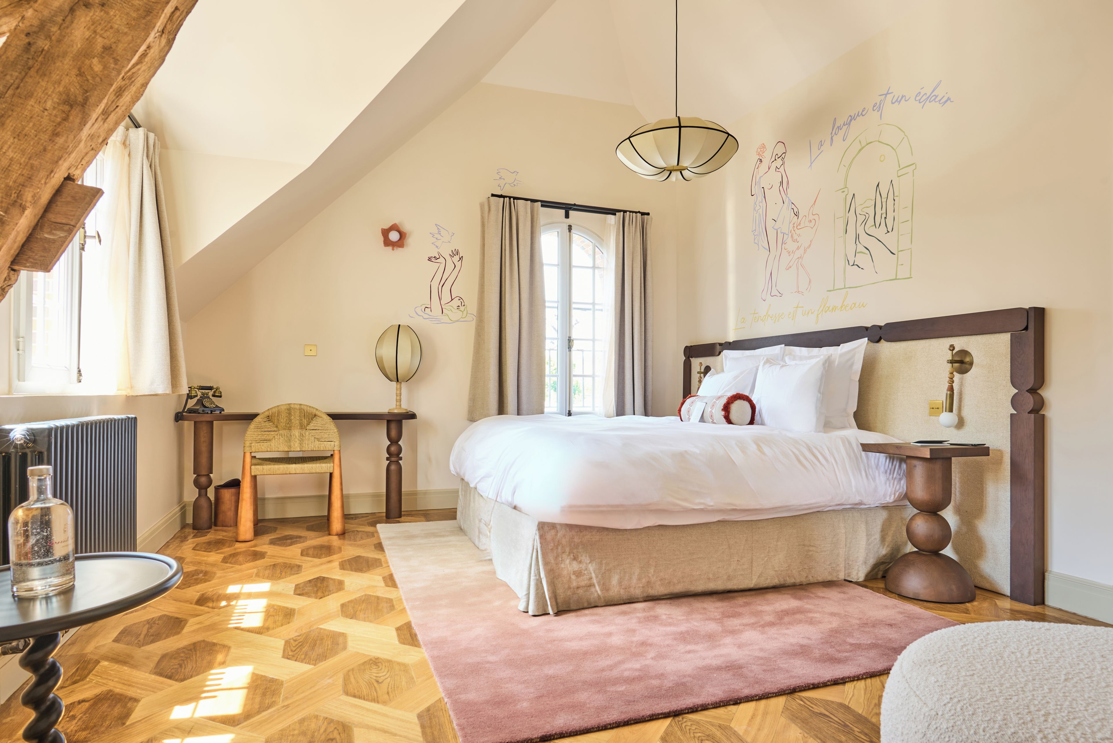 Une chambre avec un grand lit, une chaise en bois, une table avec une lampe et un radiateur.