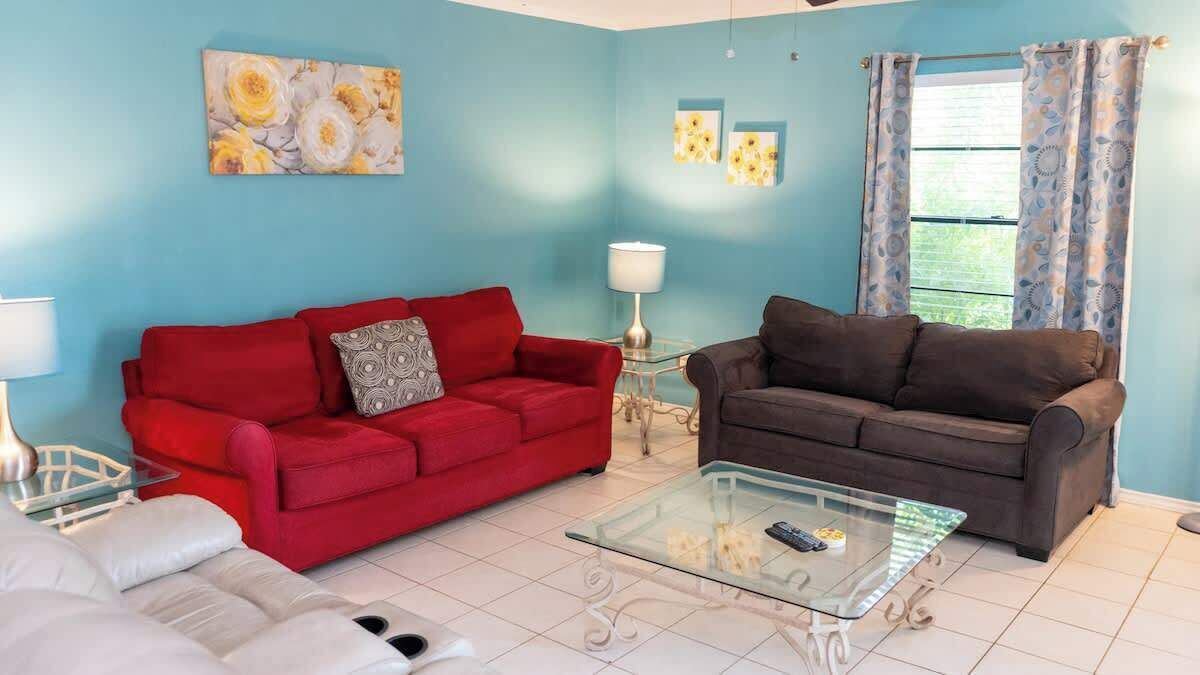 A living room with two sofas, a glass coffee table, and a lamp.