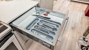 Eine Schublade mit Küchenutensilien und einem Wasserkocher.