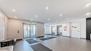 Eine geräumige Lobby mit einer Rezeption, einer Bank und einer Wand mit Wolkendekor.