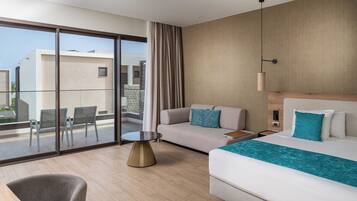 Een moderne hotelkamer met balkon, een bank, een bed en een kleine tafel.