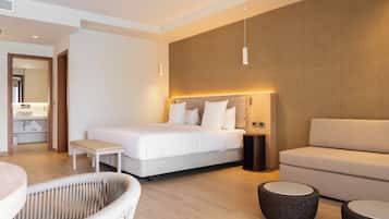 Een moderne hotelkamer met een groot bed, een bank, een klein tafeltje en een stoel.