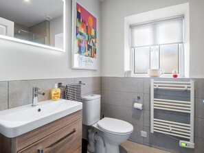 A modern bathroom with a white sink, a toilet, and a towel rack. - Rosamund Townhouse Clifden (Clifden)