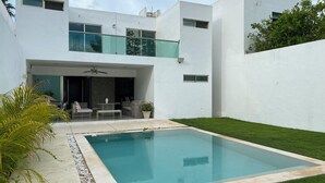 A modern two-story house with a swimming pool, outdoor seating area, and a well-maintained lawn. - Beautiful comfortable home with swimming pool (Mérida)