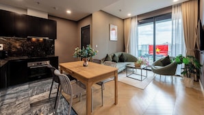 A modern living space with a kitchen, dining area, and seating. - LUMIERE Riverside Signature Residence (Ho Chi Minh City)