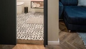 Une salle de bain moderne avec un meuble-lavabo blanc, un miroir et un porte-serviettes.