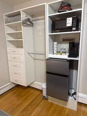 Una cocina con refrigerador integrado, microondas y cafetera sobre la encimera.