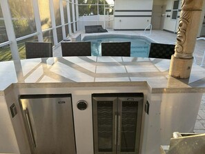 Ein Poolbereich mit Whirlpool, Liegestühlen und Blick ins Freie.