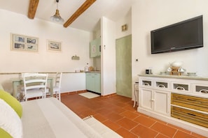 A room with a bed, a dining table with chairs, a kitchen area, and a TV mounted on the wall. - Villa Split Art - Pistacio apt (Split)