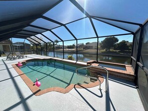 Ein überdachter Pool mit Blick auf einen See und Häuser im Hintergrund.