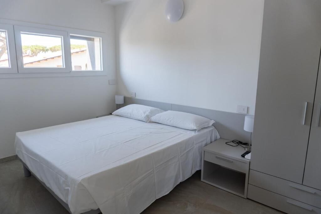 A bedroom with a bed, bedside table, and wardrobe.