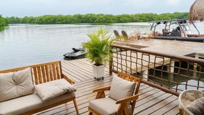 A wooden deck with a sofa and chairs, a small table, and a potted plant. - Casa Barú  (Cartagena)