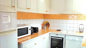 A compact kitchen with a refrigerator, microwave, toaster, stove, oven, and dishwasher. - Panoramic Sea View and Beaches on Foot (Six-Fours-les-Plages)