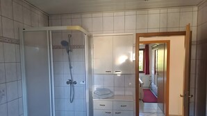 Ein Badezimmer mit Dusche, Waschbecken und Toilette.