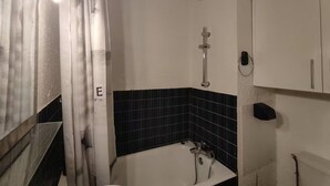 Ein Badezimmer mit Badewanne, Dusche, Toilette und Spiegel.