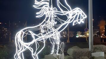 A nighttime illuminated sculpture of a horse.