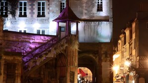 A historic building with a large central tower, a staircase leading to an upper level, and a covered entrance. - Le cottage d'Honfleur, apartment with parking! (Honfleur)