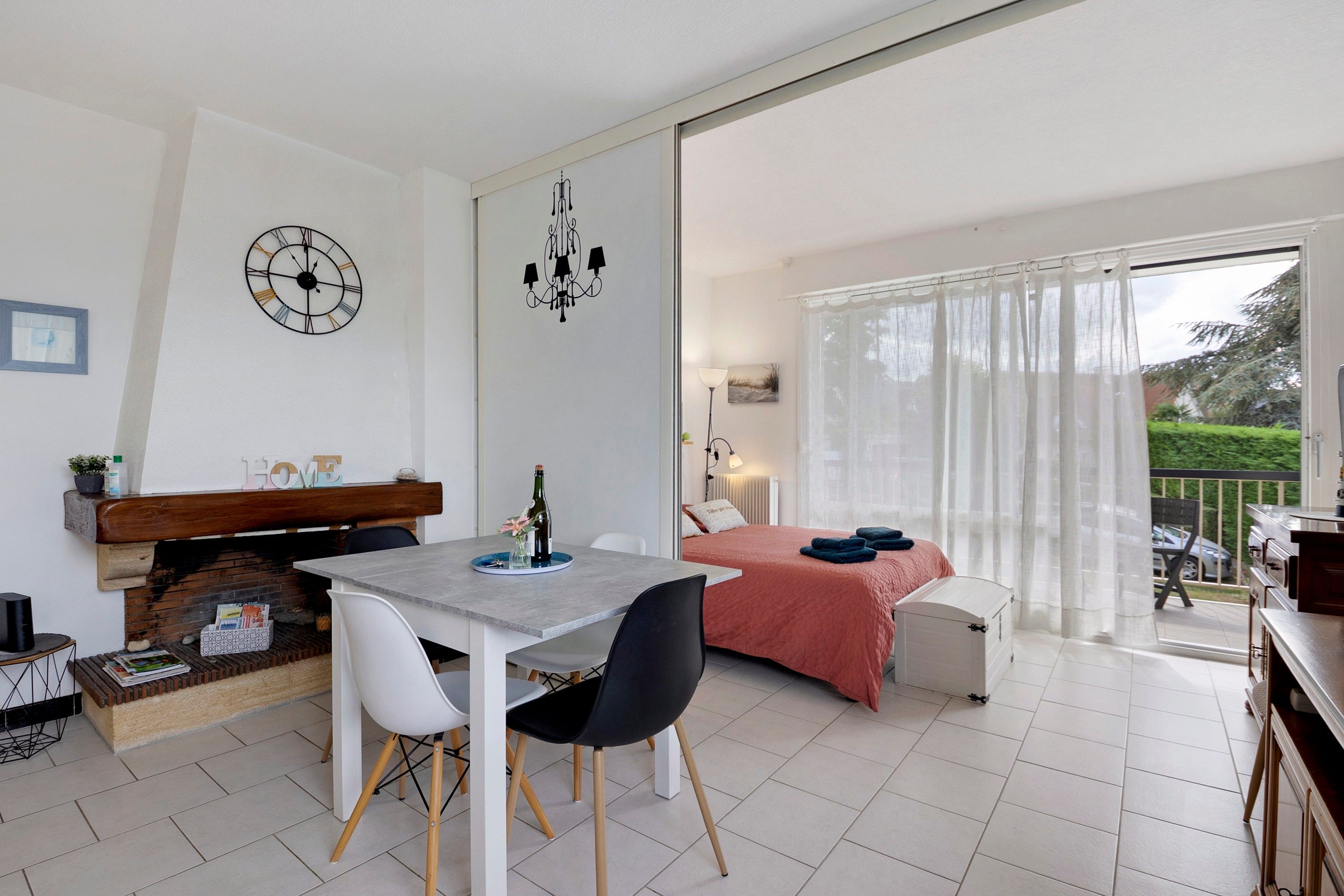 Et moderne soveværelse med seng, balkon med udsigt og spiseplads med bord og stole.