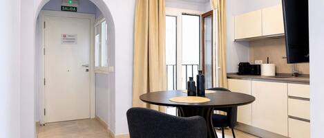 Una cucina moderna con zona pranzo, televisore e una porta con la scritta 'SALIDA'.