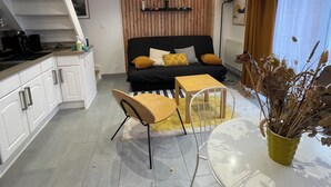Um espaço de estar moderno com cozinha, área de refeições e conjunto de sofás.