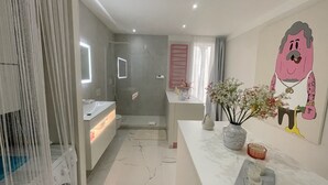 A modern bathroom with a shower, a toilet, and a sink. There is a vase with flowers on the counter. - "Rose" Atypical Cocoon in the Heart of the Upper Quarter (Sète)