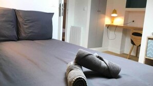 A neatly made bed with grey bedding and two rolled-up towels on it. - "Zarago 3" T3 Design in Duplex, Clim & Wifi (Sète)
