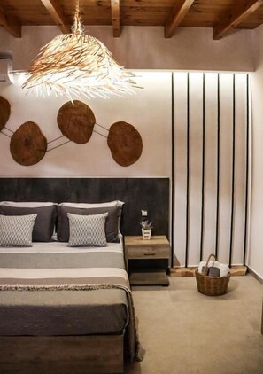 Une chambre à coucher comprenant un lit, des tables de chevet, un luminaire suspendu et un mur orné de lignes verticales.