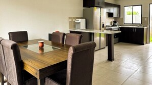 Une cuisine moderne avec un coin repas comprenant une table, des chaises et un réfrigérateur.