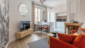 A modern living room with a TV, sofa, and dining area. - Neyret - Furnished apartment - Downtown Lyon (Lyon)