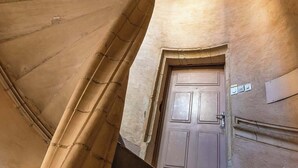 A spiral staircase with a wooden handrail and a door at the bottom. - Neyret - Furnished apartment - Downtown Lyon (Lyon)