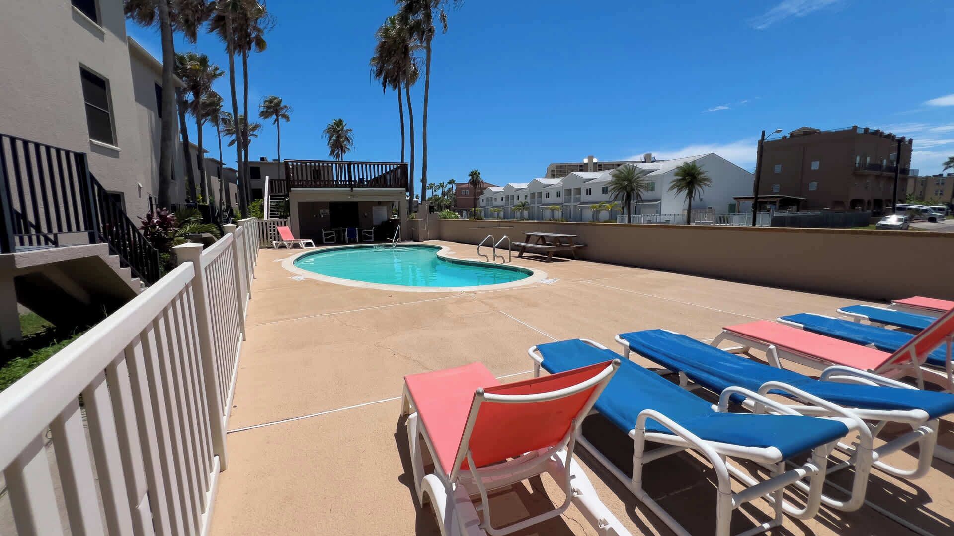 A rooftop pool area with lounge chairs and a swimming pool.