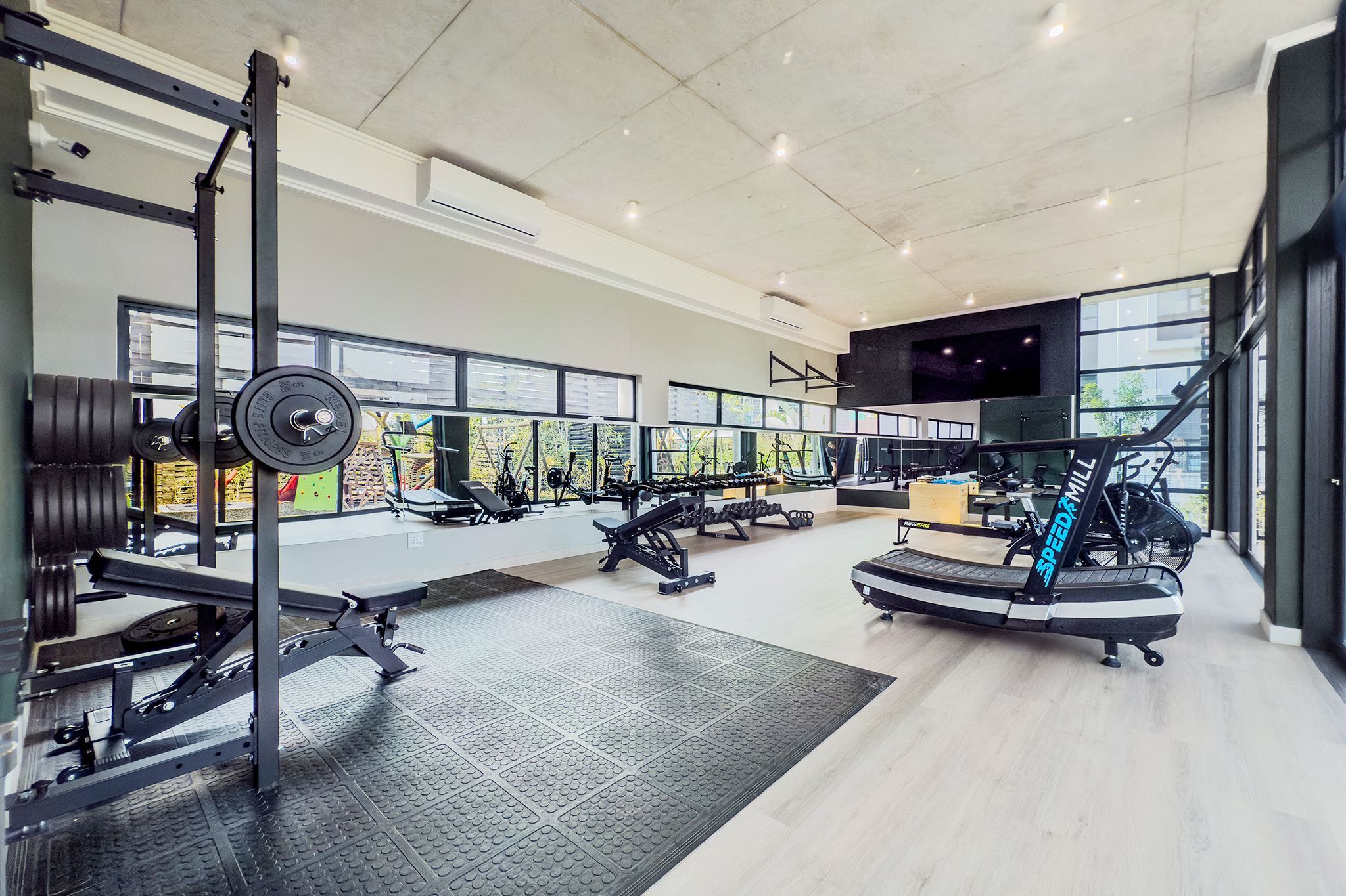 Ett gym med utrustning för styrketräning, löpband och träningsmaskiner.