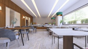 Un comedor moderno con suelo de mármol, detalles de madera e iluminación colgante.