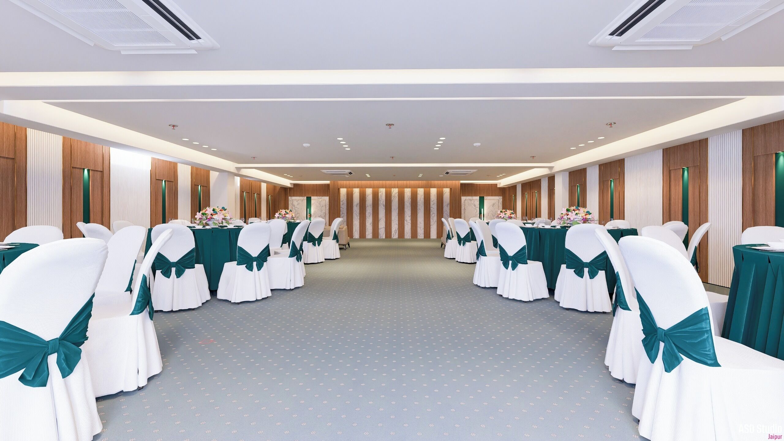 A conference room with rows of white chairs with teal sashes, tables with green tablecloths, and a wooden panel wall with vertical stripes.