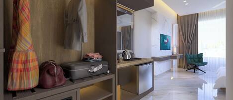 A modern hotel room with a wooden wardrobe, a seating area with a green chair, a television, and a marble floor.