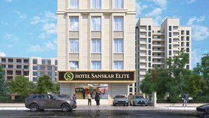 Un moderno edificio de hotel con un letrero que dice "Hotel Sanskar Elite".