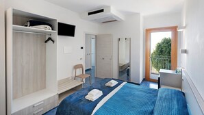 Quarto com cama, guarda-roupa, cadeira e vista para a varanda.