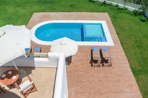 A rooftop pool area with a rectangular swimming pool, lounge chairs, and a table with umbrellas. - My Villa Naxos Iiii (Naxos)