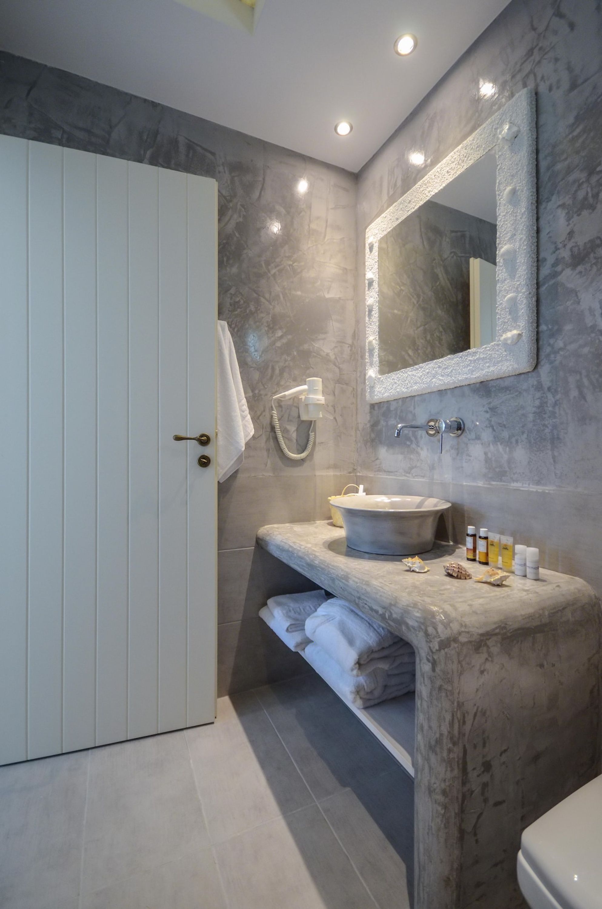 A bathroom with a marble vanity, a large mirror, and a towel rack.