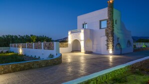 A modern building with a stone facade, arched entryway, and a chimney. - My Villa Naxos II (Naxos)